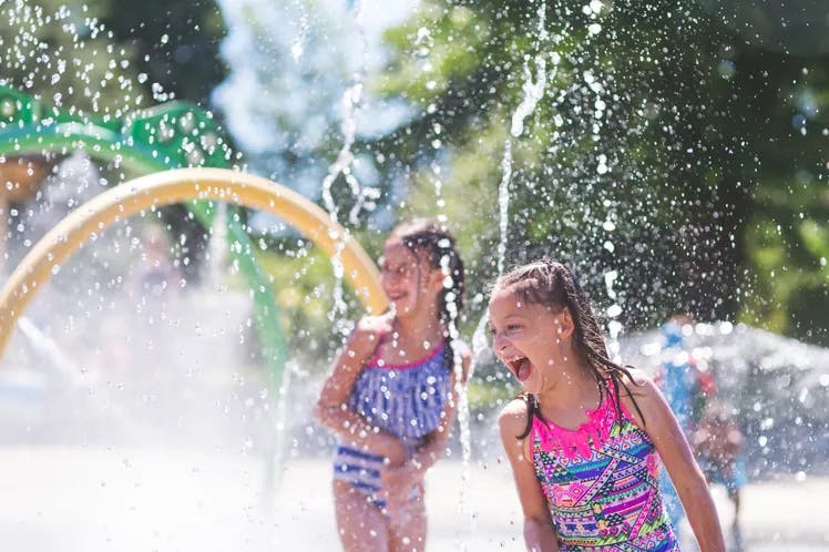 two children playing in a splash pad